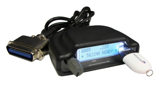 This picture is of the Tajima USB Reader product. It is a newer alternative to floppy disk drive based readers, such as the obsolete Tajima TFD-II or TFD-2. It is meant to provide a direct link between a USB stick and your Tajima Embroidery machine, usually the older models such as the TME-600, TMEF-906, etc. The Tajima USB key may be deattached, and another brand of key inserted.